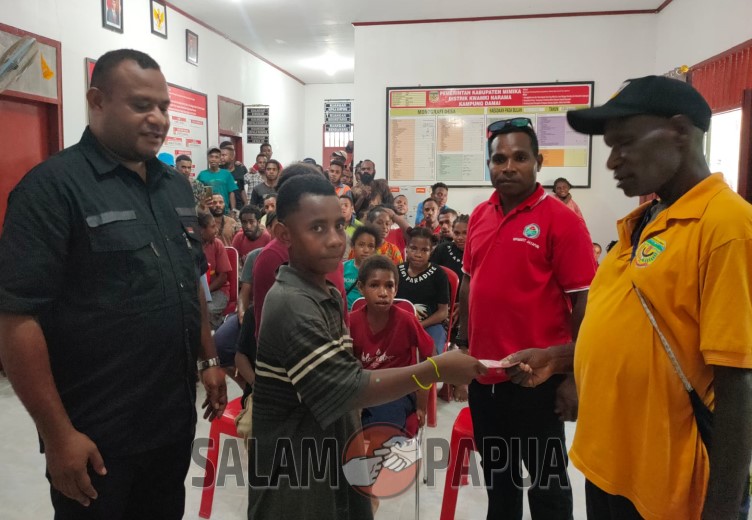 Kepala Kampung Damai, Luter Wonda saat menyerahkan bantuan beasiswa kepada seorang pelajar SMP (salampapua.com/Acik)