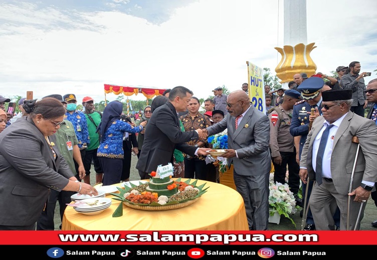 Pemberian tumpeng oleh Pj Bupati Mimika Valentinus Sudarjanto Sumito kepada Ketua DPRD Mimika Anton Bukaleng (salampapua.com/Evita)