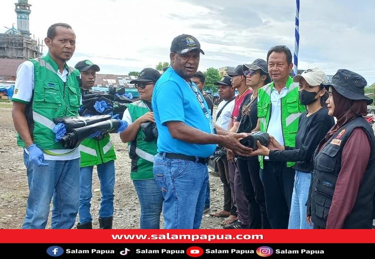 Penyerahan kantong sampah dan sarung tangan oleh Kepala Dinas DLH Mimika, Frans Kambu (salampapua.com/Evita)